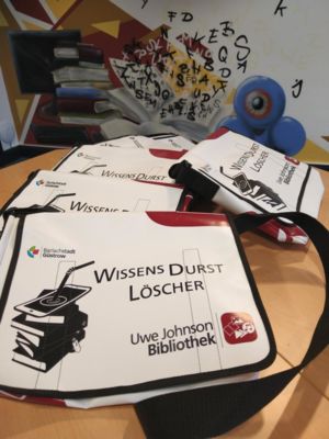 Mehrere Taschen aus LKW-Plane mit dem Aufdruck "WissensDurstLöscher", die nun in der Bibliothek mit ausgeliehen werden können.
