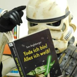 Stormtrooper liest in einem Buch, mit dem Titel "Yoda ich bin, alles ich weiß" und tippt sich an die Stirn; (c) German Garrison