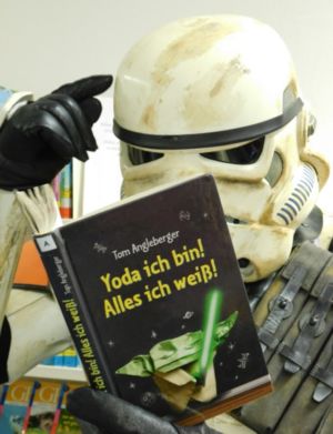 Stormtrooper liest in einem Buch, mit dem Titel "Yoda ich bin, alles ich weiß" und tippt sich an die Stirn; (c) German Garrison